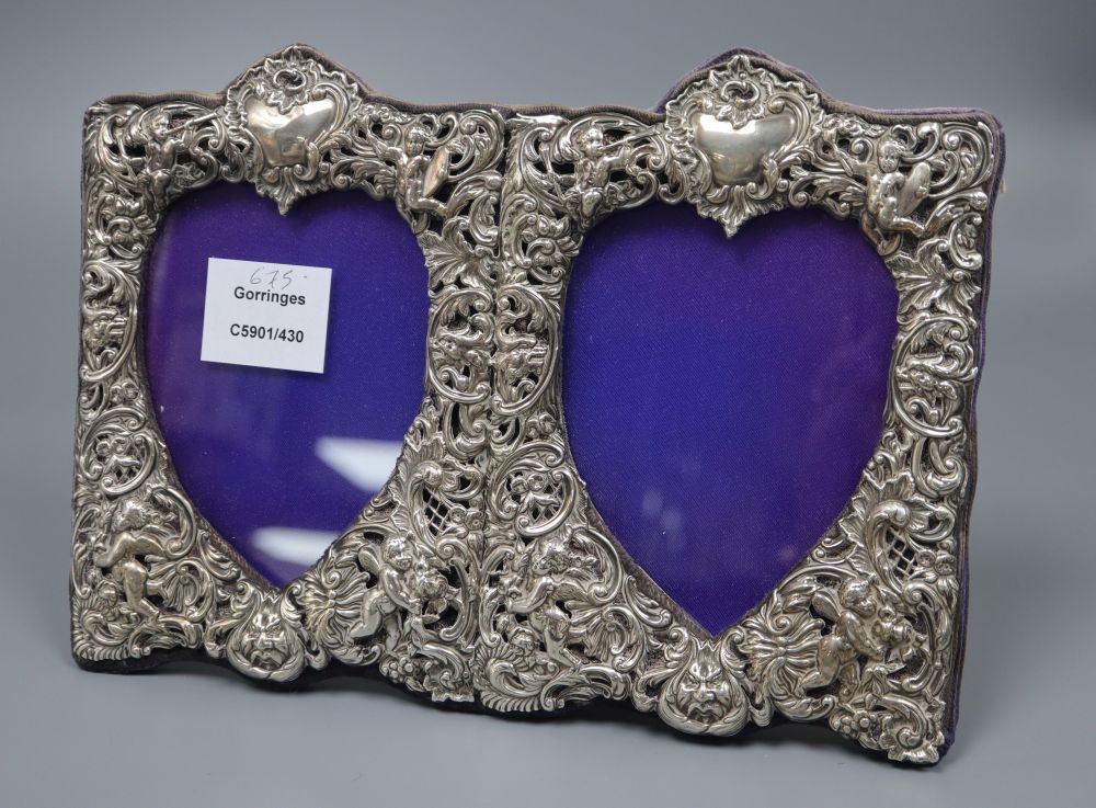 A late Victorian repousse silver mounted double photograph frame, with heart shaped apertures,